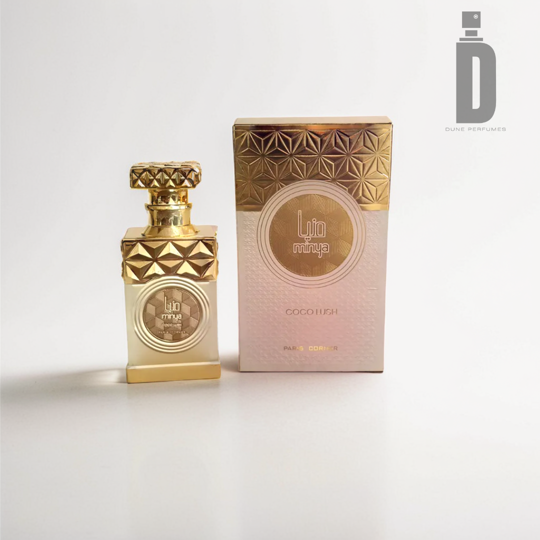 A gold-capped perfume bottle featuring intricate geometric patterns is displayed beside its matching box, labeled "Minya Coco Lush" by Paris Corner. The opulent gold and pale pink design suggests notes of coconut milk, wrapping you in a warm embrace.