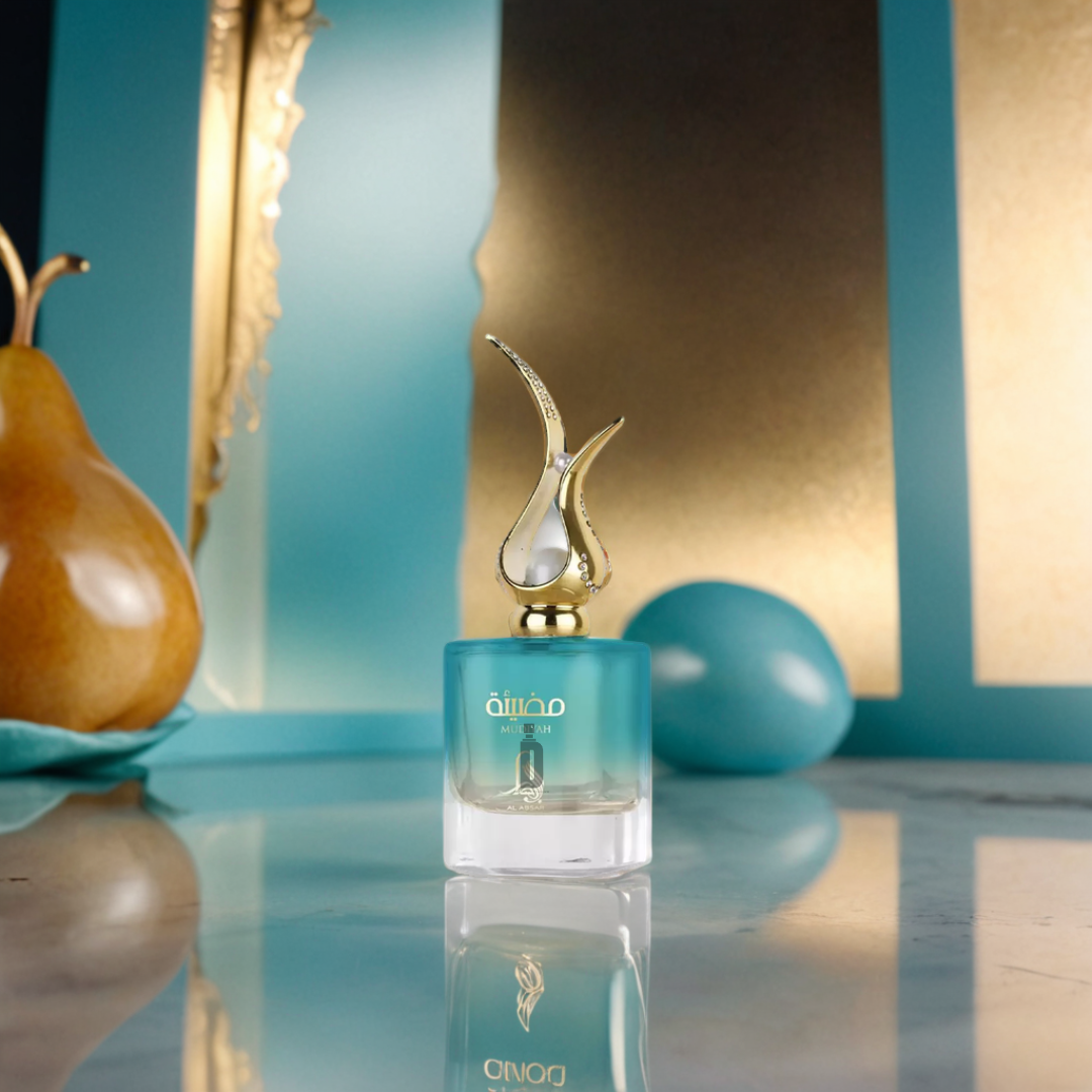 A blue and gold Mudiyah 100ml EDP by Al Absar with an ornate gold cap sits on marble. Nearby are a golden pear, a turquoise egg, and gold-trimmed blue panels, creating an elegant scene that hints at a long-lasting fragrance.