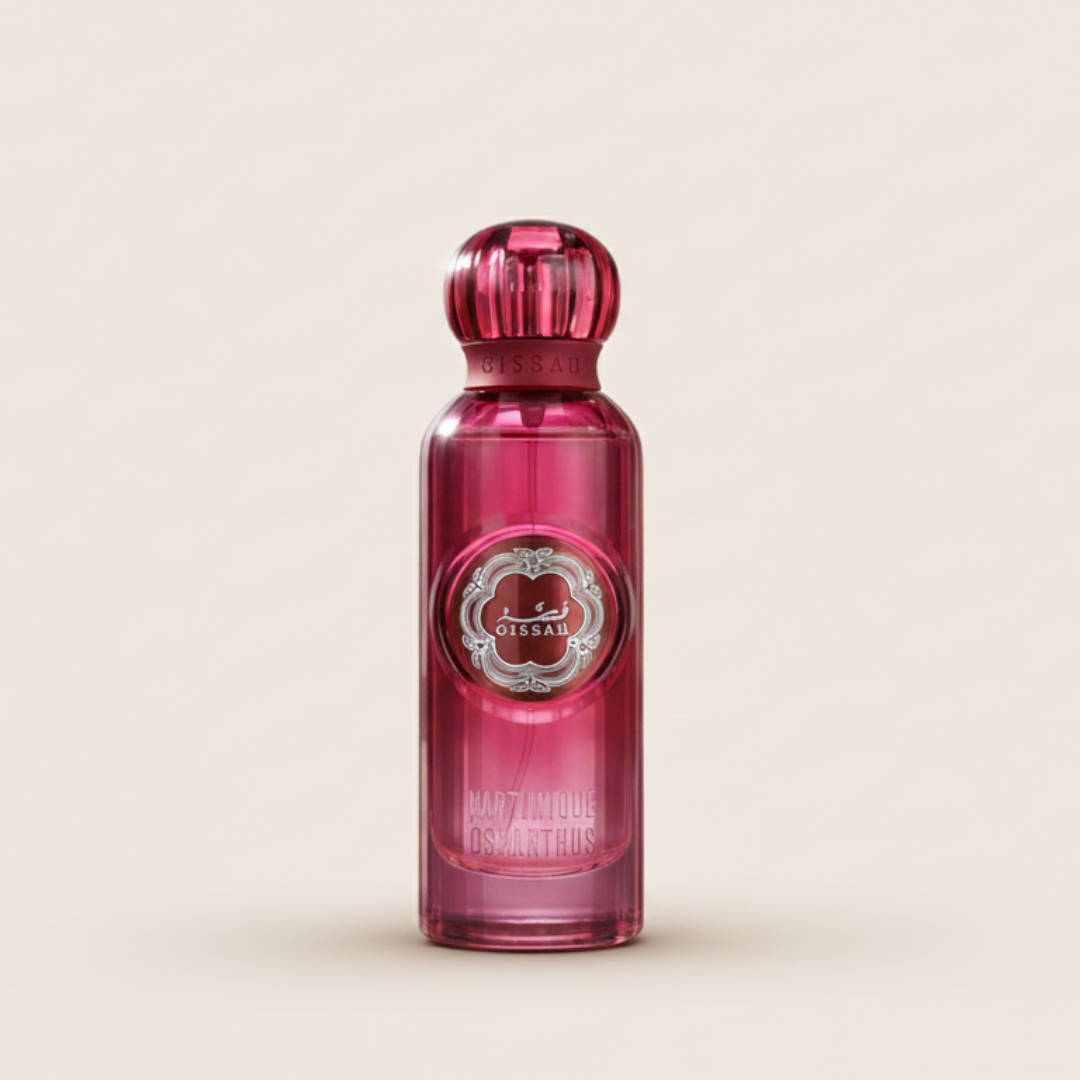 A pink perfume bottle with a round cap and silver label reading "Gissah" and "Martinique Osmanthus 200ml EDP" stands upright on a light beige background, reflecting its luxurious floral fragrance.