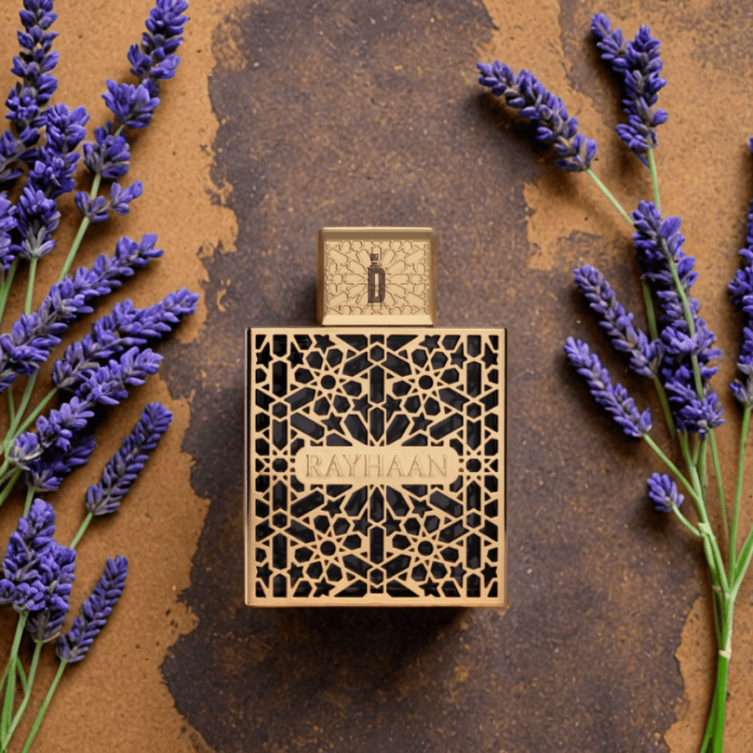 The Rayhaan Elixir 100ml EDP by Rayhaan features a decorative bottle with a gold geometric pattern, placed on a brown surface and surrounded by fresh lavender sprigs and hints of vanilla.