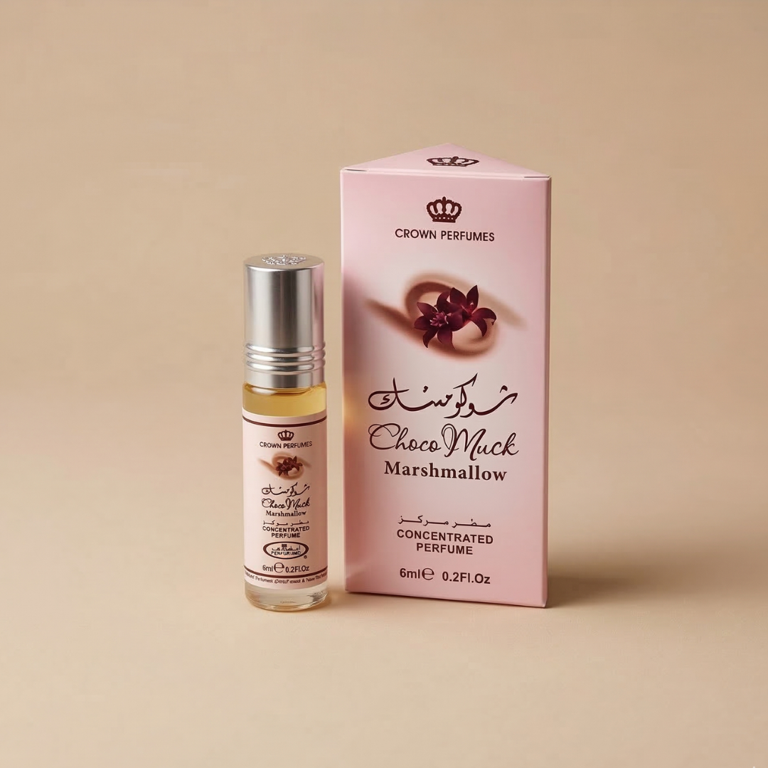 A small glass bottle of Al Rehab Choco Musk Marshmallow perfume is displayed beside its pink and beige box, which features decorative text and a floral design, on a beige background.