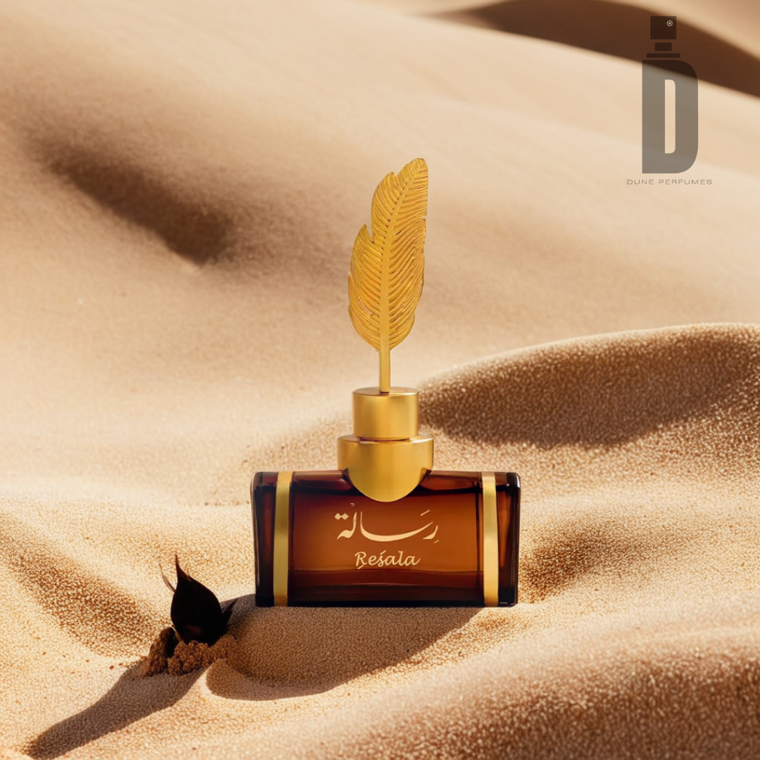 A Resala 100ml EDP by Arabian Oud, in a brown bottle with a gold feather-shaped cap, is perched on sand dunes. Its luxurious scent, enriched with exotic spices, envelops the air. The pristine sand extends into the distance. The logo of Dune Perfumes is gracefully positioned at the top right corner.