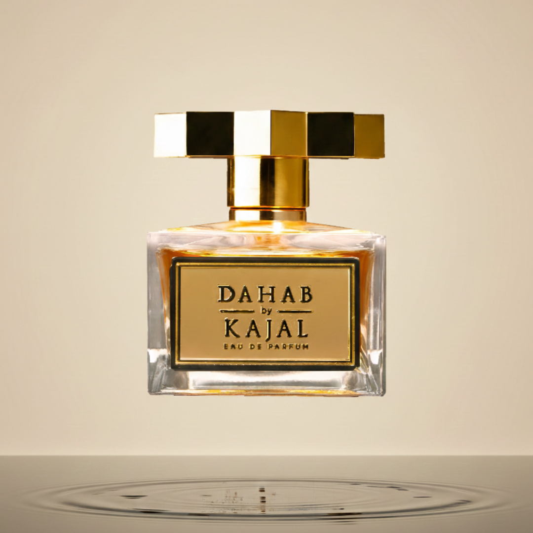 A square glass bottle labeled "Dahab 100ml EDP - Kajal," with a gold geometric cap, floats above rippling water against a beige backdrop—an elegant display of Kajal’s captivating fragrance.