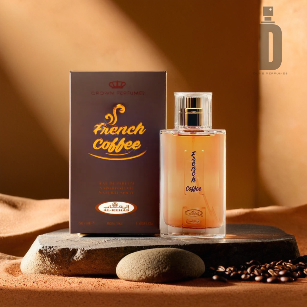 A 50ml bottle of "French Coffee" Eau de Parfum by Al Rehab stands beside its brown packaging on a stone slab. Coffee beans and a hint of caramel are scattered around, with warm lighting enhancing the scene. Al Rehab's logo is visible in the top right corner, adding a touch of elegance to this aromatic display.