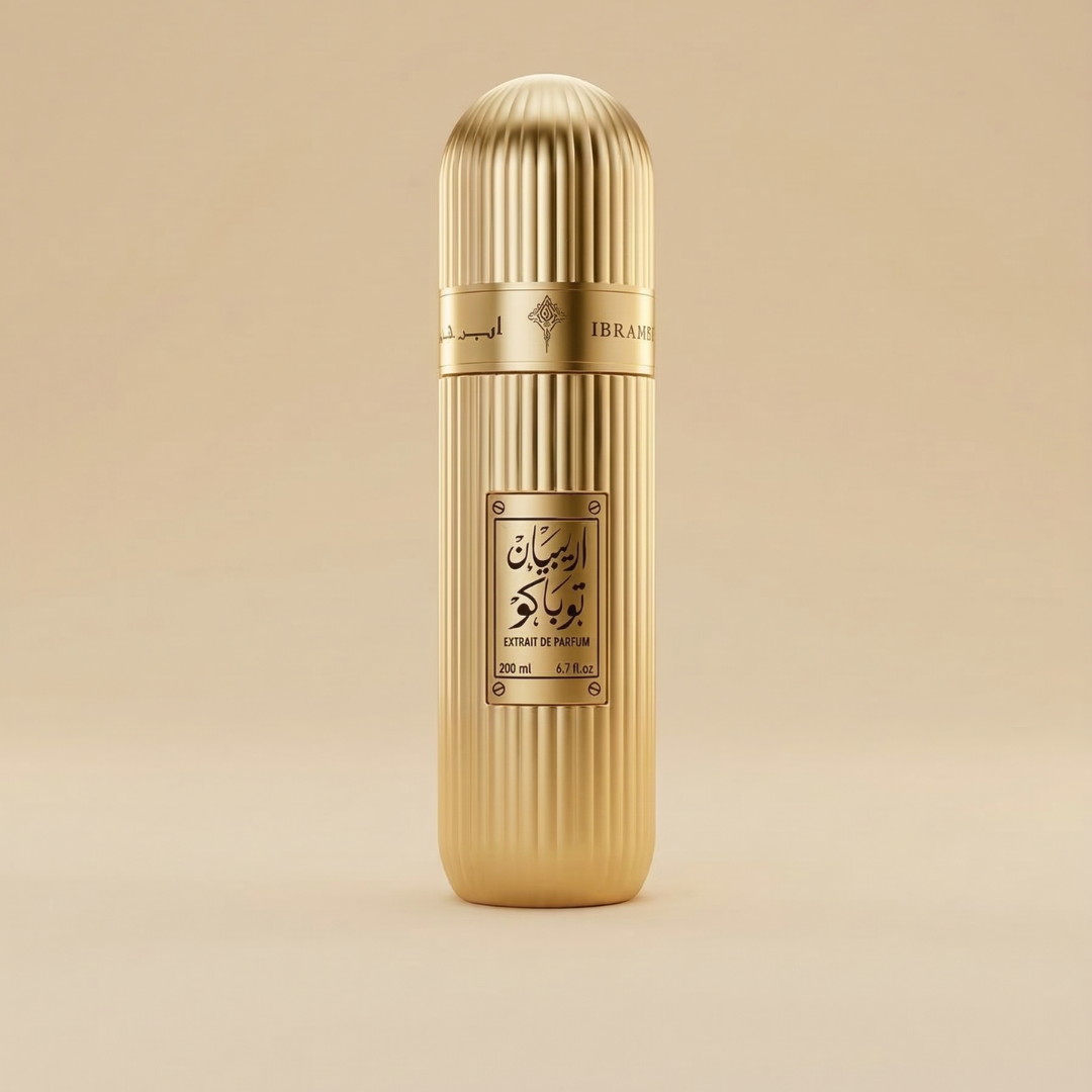 The Arabian Tobacco 100ml EDP by Ibrahim Al Qurashi stands upright against a plain beige background—a tall, gold, cylindrical bottle with vertical ridges, rounded top, and Arabic script on the label that evokes an oriental allure.