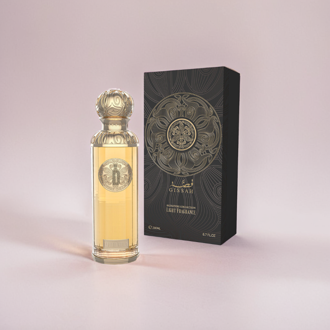 A 200ml bottle of Gissah Liquid Gold EDP, featuring a gold-accented design, stands beside a decorative black and gold box on a light pink background. The fragrance's intricate cap and label pattern exudes opulence.