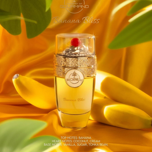 Displayed amidst bananas and vivid yellow fabric, the elegant Banana Bliss 100ml EDP by Paris Corner radiates a tropical aroma with scents of banana, coconut, cream, vanilla, sugar, and tonka bean. The luxurious bottle features an intricate golden design crowned with a red jewel.
