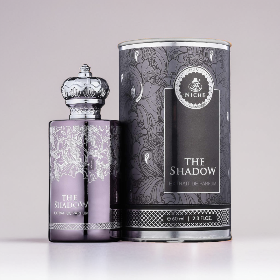 The elegant perfume bottle and matching cylindrical box showcase ornate silver floral designs on a light purple and gray background, with text reading "The Shadow Extrait 60ml - Fragrance World," capturing this exquisite fragrance's essence.