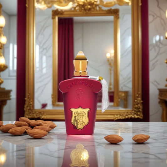 A luxurious red bottle of Xerjoff Italica Casamorati 100ml EDP with a gold cap and tassel rests on marble among almonds, while an ornate mirror and red curtains evoke the perfume's rich, gourmand vanilla notes.