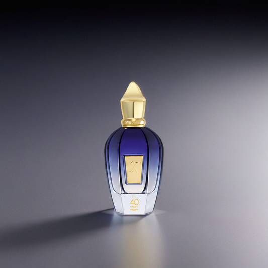 A blue and gold Xerjoff 40 Knots 100ml EDP perfume bottle with a gold cap and label, displaying "40" at the base, stands on a smooth gradient gray surface, reflecting its aquatic-woody allure.