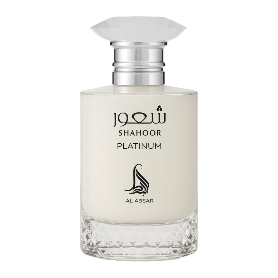 A clear glass bottle with a faceted cap holds Shahoor Platinum 100ml EDP by Al Absar. The pale liquid is labeled with "SHAHOOR PLATINUM" and Arabic script above, plus the Al Absar logo below—a refined Eau de Parfum.