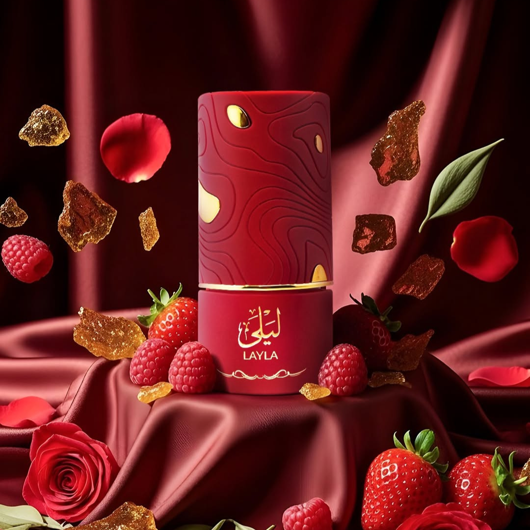 A red bottle of Layla 100ml EDP by Al Absar sits on satin, surrounded by berries, rose petals, and amber sugar, creating a rich and luxurious ambiance that reflects its feminine fragrance.