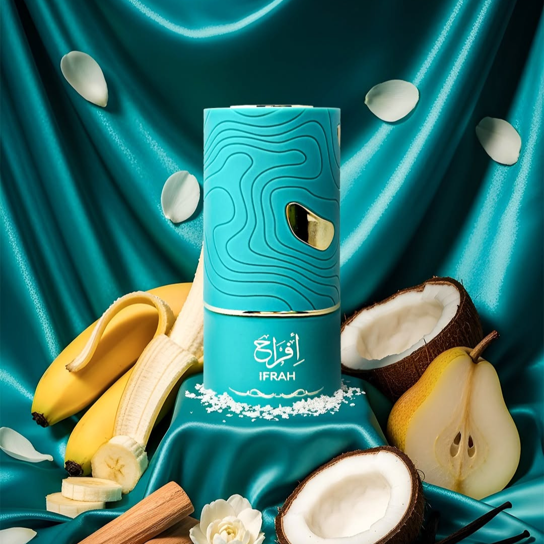 A turquoise cylindrical bottle of Ifrah 100ml EDP by Al Absar rests on teal satin, surrounded by banana, coconut, pear, cinnamon sticks, white petals, and coconut flakes—creating a vibrant Eau de Parfum scene.