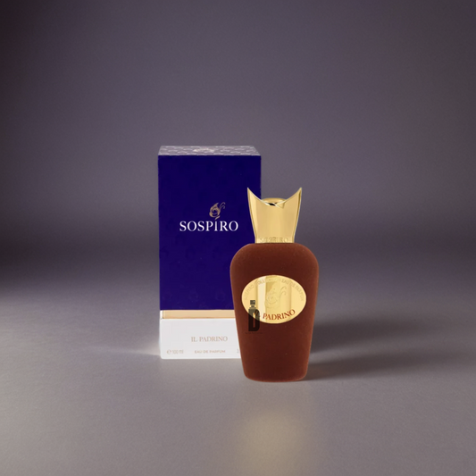 A brown velvet Sospiro Il Padrino 100ml EDP bottle with a gold cap and label stands before a matching blue and gold box on a softly lit gray background, capturing the commanding fragrance of Sospiro.