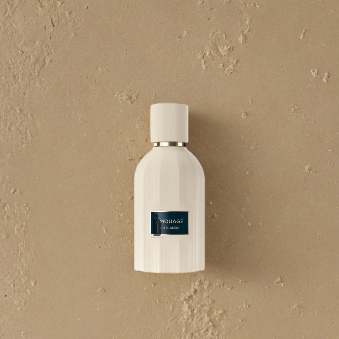 A white perfume bottle with a gold rim and a dark label reading "Amouage Outlands 100ml EDP" rests on a textured beige surface, suggesting the refined scent inside from Amouage.