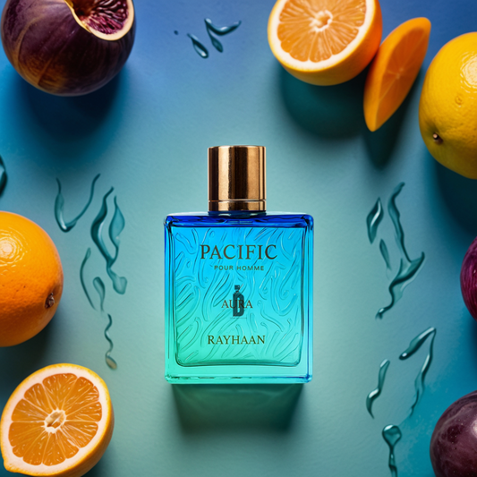 A blue and green bottle of Pacific Aura 100ml EDP by Rayhaan rests on a blue surface with halved citrus fruits and figs, evoking a fresh, uplifting scent. Water droplet designs accent the vibrant display.