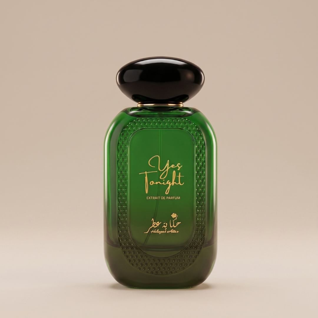 The Yes Tonight 100ml Extrait De Parfum by Hekayat Attar features a green glass bottle with gold text and Arabic script, topped with a black cap. This bold, modern scent offers lasting sweetness in an elegant design.