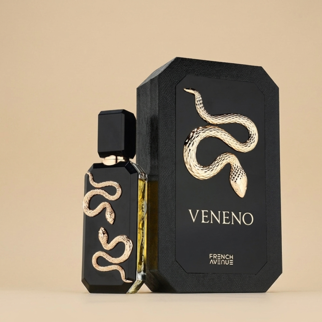 A black perfume bottle and matching box, both featuring a gold snake motif and labeled "VENENO" and "FRENCH AVENUE," showcase Veneno 100ml EDP by Fragrance World, standing out on a plain beige background.