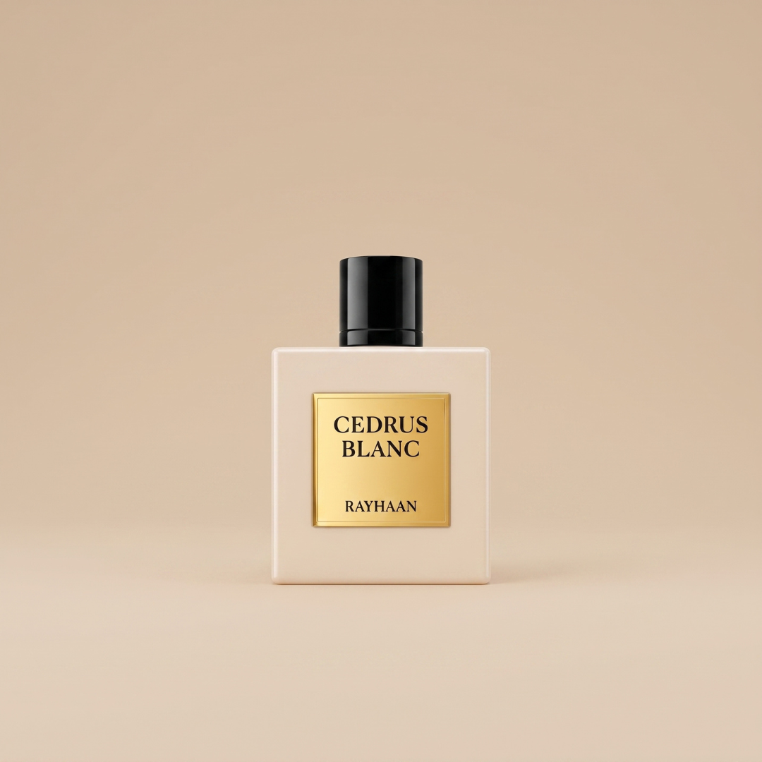 A square perfume bottle with a black cap and a gold label reading “Cedrus Blanc 100ml EDP - Rayhaan” from Rayhaan sits on a beige surface against a beige background, capturing the essence of this cedarwood fragrance with its fresh, elegant aroma and delicate hint of bergamot.