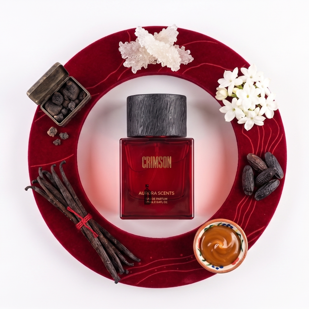 Crimson 100ml EDP by Aurora Scents features a red bottle in a circular frame, surrounded by vanilla beans, white flowers, resin crystals, and amber liquid—a warm gourmand scent ideal for vanilla caramel perfume lovers.