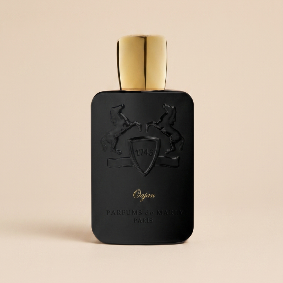 A sleek black bottle of Oajan 120ml EDP by Parfums De Marly, featuring a gold cap and an embossed design of two rearing horses with a shield marked "1743." The inscription below reads "Oajan, Parfums de Marly, Paris." Celebrated for its opulent amber scent, this fragrance by Parfums De Marly is elegantly showcased against a beige background.