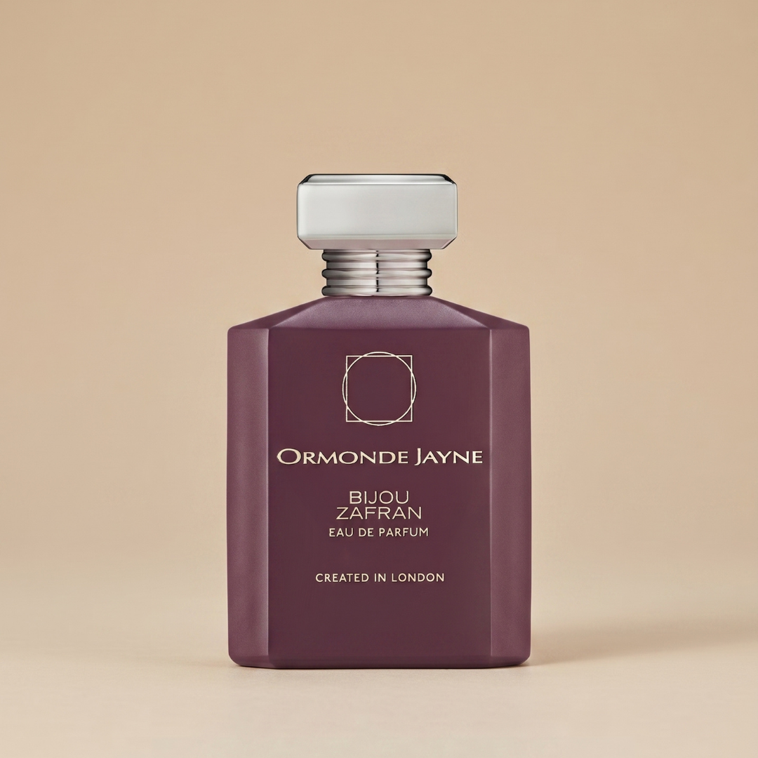An elegant maroon bottle labeled “Bijou Zafran 88ml EDP - Ormonde Jayne,” topped with a silver cap, is displayed against a beige background, embodying the luxury of Ormonde Jayne’s signature fragrance with refined saffron nuances.