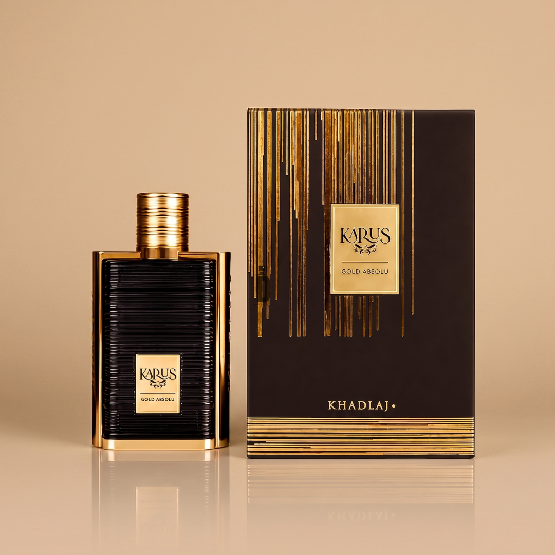 A sleek black and gold perfume bottle labeled “Karus Gold Absolu 100ml EDP - Khadlaj” stands beside its matching black and gold box featuring the Khadlaj brand, both displayed against a beige background. This luxurious fragrance by Khadlaj exudes elegance, making it an ideal choice for those seeking a refined scent experience.