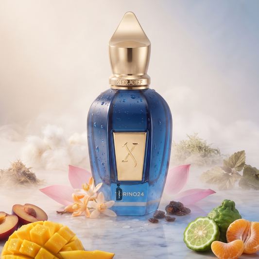 A bottle of Xerjoff Torino 24 50ml EDP, adorned with a striking blue design and a gold cap, is artfully displayed on a marble surface amid fresh fruits, delicate flowers, and glistening dewdrops, evoking the exotic spirit of this fragrance against a backdrop of mist and gentle light.