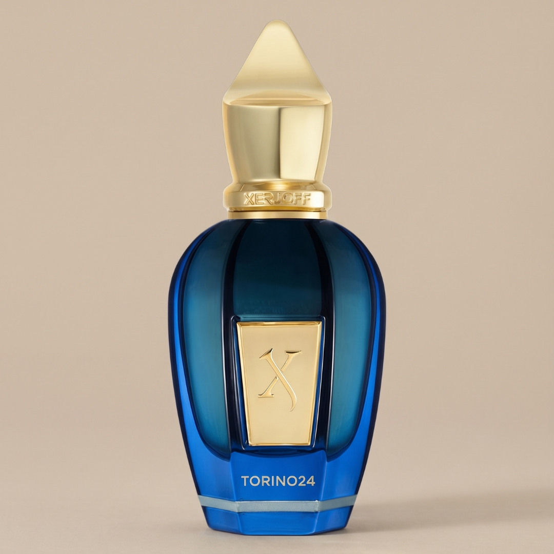 A sophisticated blue Xerjoff perfume bottle with a gold cap and a gold label featuring the Xerjoff name sits against a plain beige background. A label on the base reads “Torino 24,” suggesting an exotic fragrance inside this 50ml EDP offering from Xerjoff.