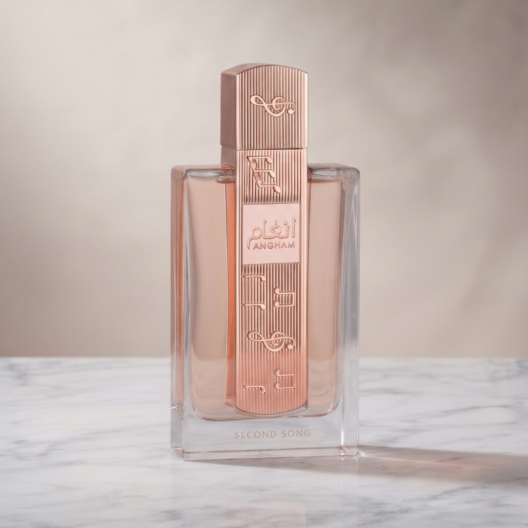 A bottle of Angham Second Song 100ml EDP by Lattafa, adorned with rose gold accents and elegant Arabic script, rests gracefully on a white marble surface against a blurred beige background—capturing the true floral essence inspired by Lattafa’s signature fragrance.