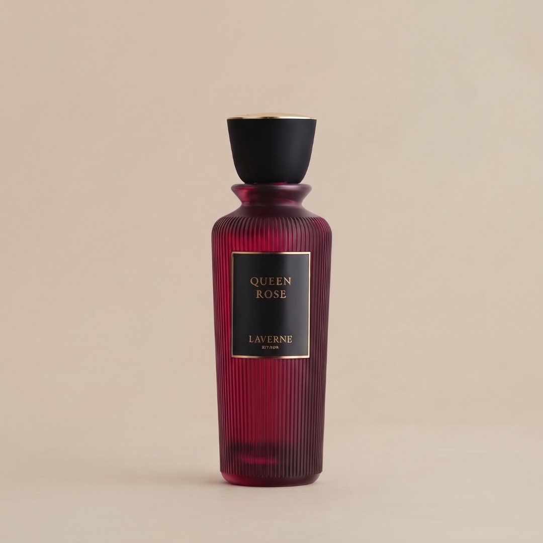 A striking, tall perfume bottle from Laverne features an elegant ribbed red design and a sophisticated black and gold cap. The label displays “Queen Rose 200ml EDP - Laverne” in gold lettering on a sleek black background. This Queen Rose fragrance by Laverne encapsulates a luxurious floral essence, its beauty highlighted against a simple beige backdrop.