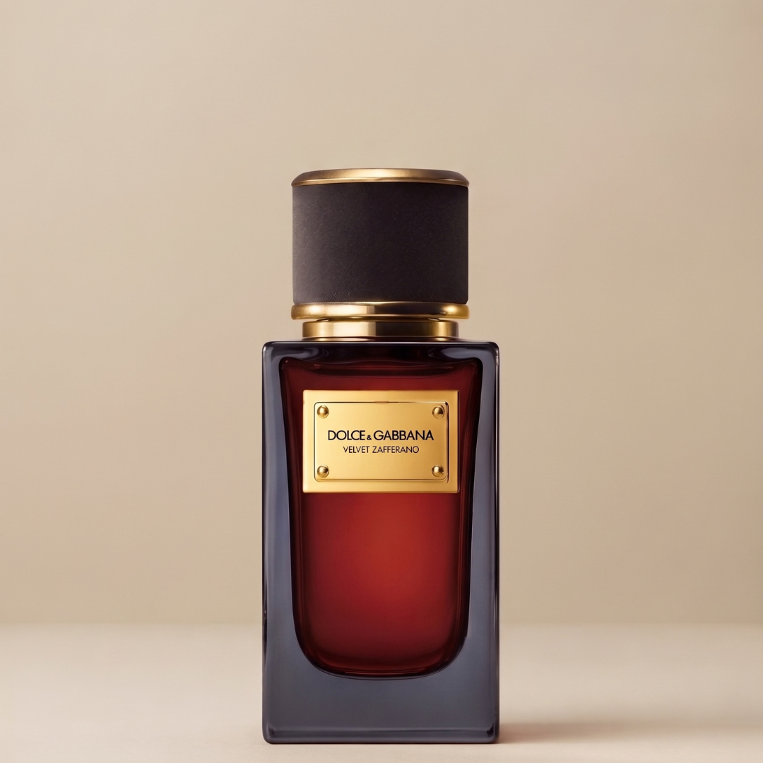A rectangular glass bottle of Dolce & Gabbana Velvet Zafferano 100ml EDP with deep red liquid, a black cap, and a gold metal label.