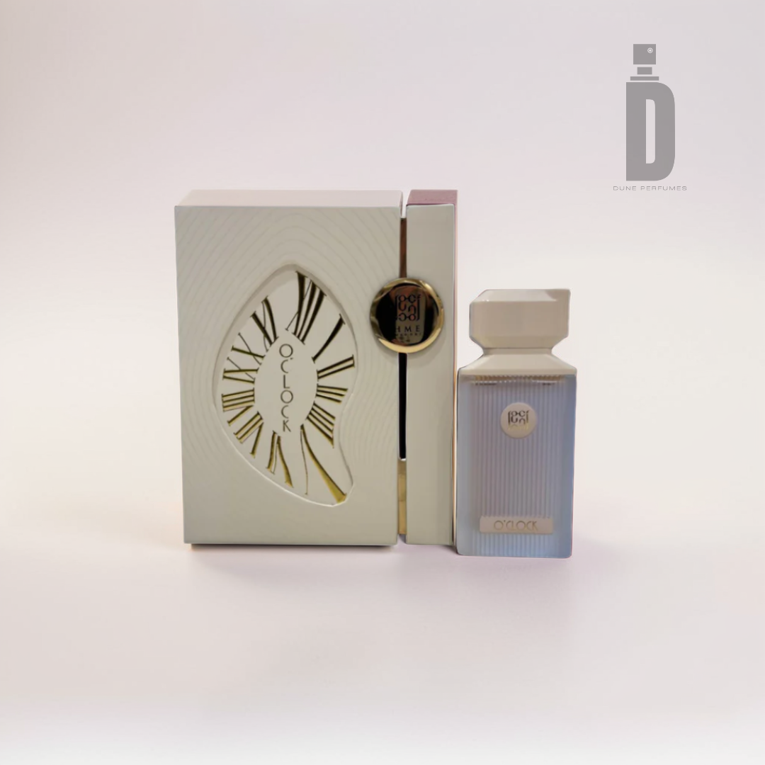 Experience new adventures with the O'clock 100ml EDP by Ahmed Al Maghribi. This perfume set includes a closed white and gold box adorned with an abstract clock design, complemented by a matching rectangular bottle. The elegant ensemble delivers a refreshing burst of citrus against a pristine white background.