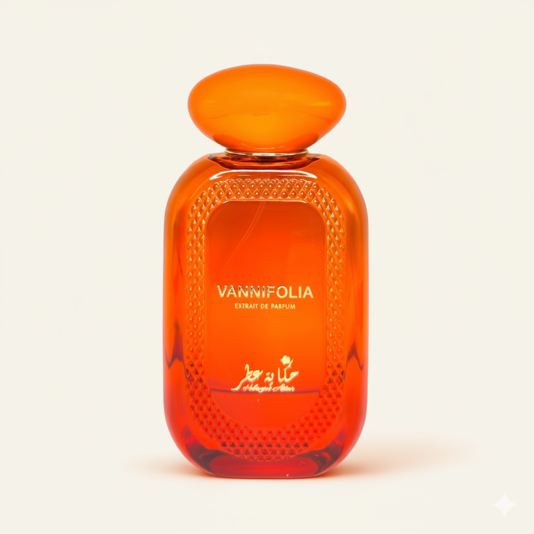 A vibrant orange "Vannifolia 100ml EDP" perfume bottle by Hekayat Attar, adorned with gold text and decorative patterns, stands out against a plain light background, evoking the essence of a rich gourmand fragrance.