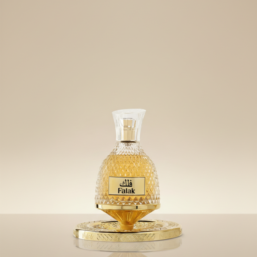 The Falak 100ml EDP by Riiffs for Nusuk features a gold and glass bottle with Arabic script on an ornate gold base, set against a soft beige backdrop—ideal for fans of lavish gourmand caramel fragrances.