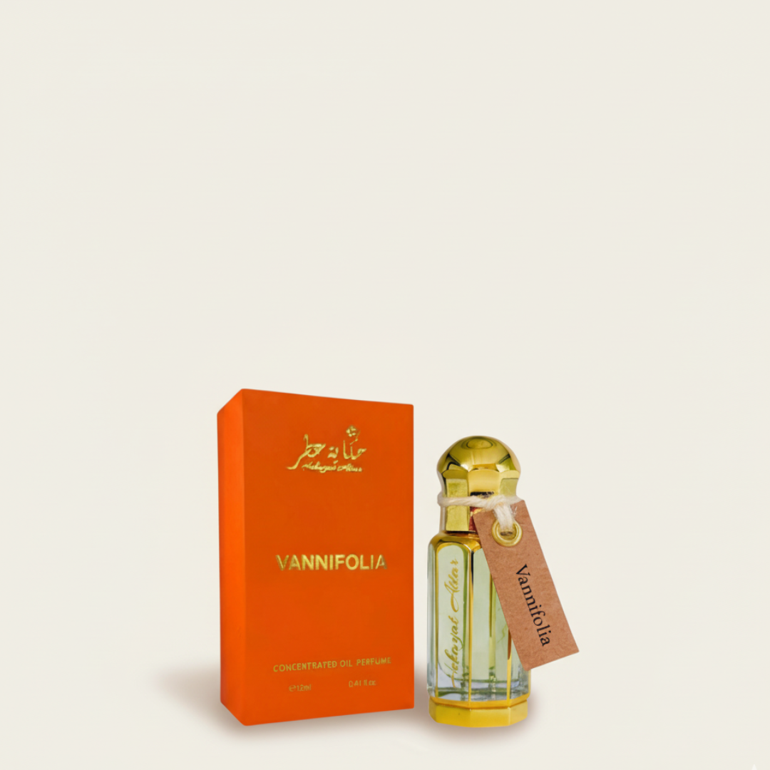 A Vannifolia 100ml EDP by Hekayat Attar, featuring a golden-capped bottle with a tag, is positioned beside an orange box with gold lettering reading "Vannifolia" and "Concentrated Oil Perfume" on a light background.