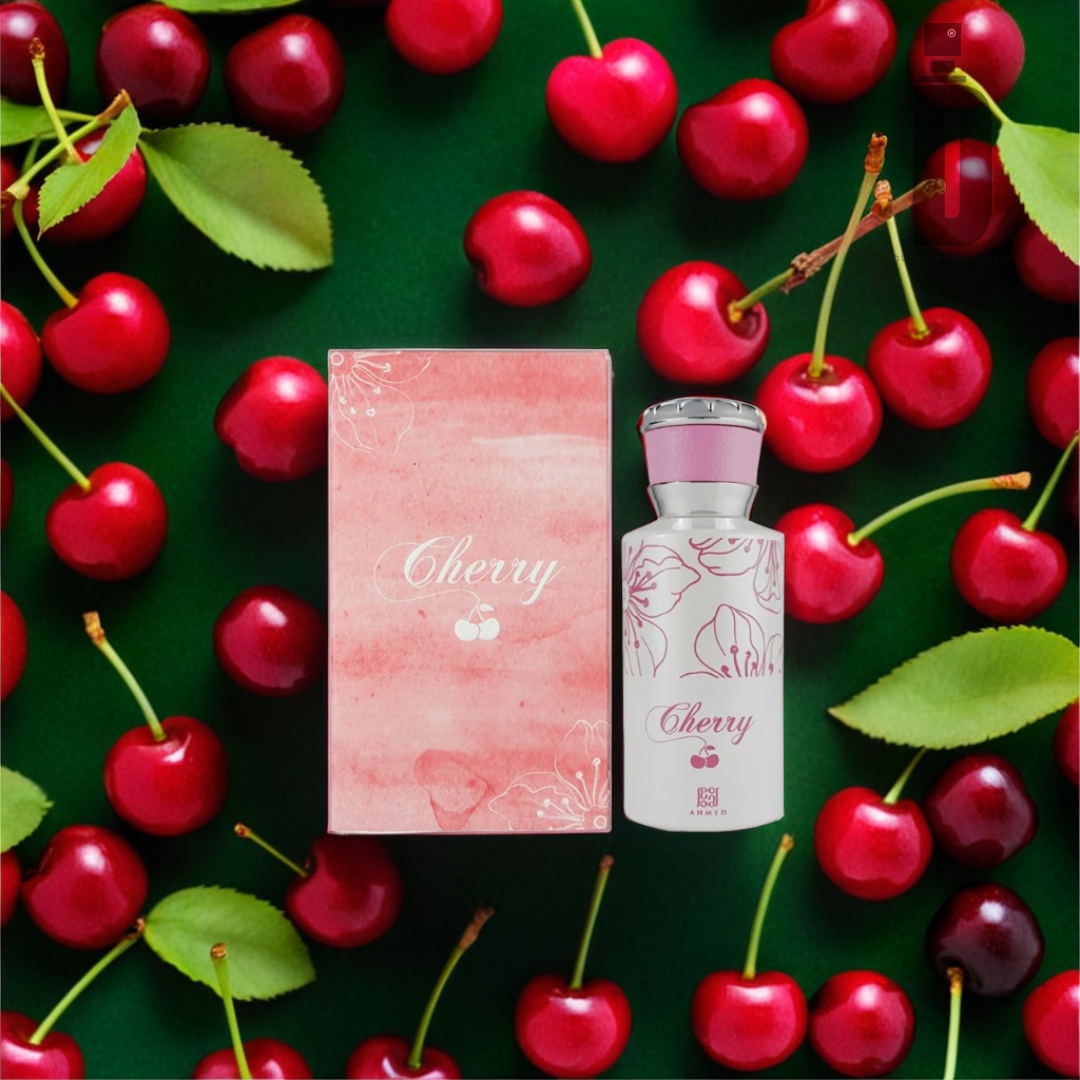 A bottle of Cherry 50ml EDP by Ahmed Al Maghribi and its matching box, adorned with a cherry design, are surrounded by fresh red cherries with green leaves. Both the box and bottle feature a delicate pink and white theme, with "Cherry" printed on each. The dark green background accentuates the fruity sweetness of this fragrance by Ahmed Al Maghribi.