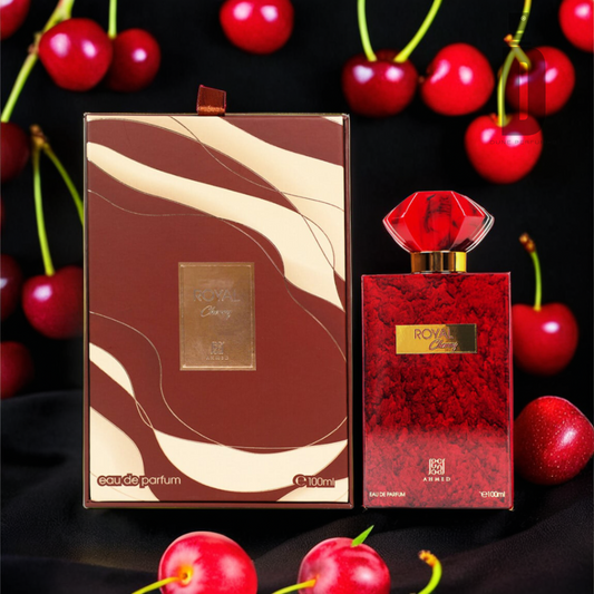 A luxurious perfume bottle with a gem-like red cap labeled "Royal Cherry" stands next to its matching box against a backdrop of fresh cherries. The box, adorned with elegant gold and red wavy patterns, echoes the sophistication found in Tom Ford's Lost Cherry Eau de Parfum. Both the bottle and box from Ahmed Al Maghribi's Royal Cherry 100ml EDP are 100 ml in size.