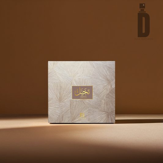 A beige and gold square perfume box with ornate patterns displayed against a light brown background. A gold label on the front features Arabic text in elegant script, hinting at the enchanting scent of Takhyyal Bakhoor (6 tablets) from Ahmed Al Maghribi. The logo for "Ahmed Al Maghribi" is visible in the top-right corner.
