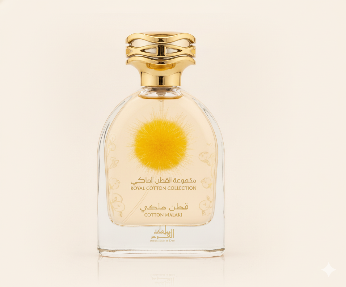 A clear 100ml perfume bottle with a gold cap from Mamlakat Al Oud, labeled "Cotton Malaki" in English and Arabic, features a soft yellow puff inside—an everyday scent embodying soft luxury from the Cotton Malaki EDP collection.