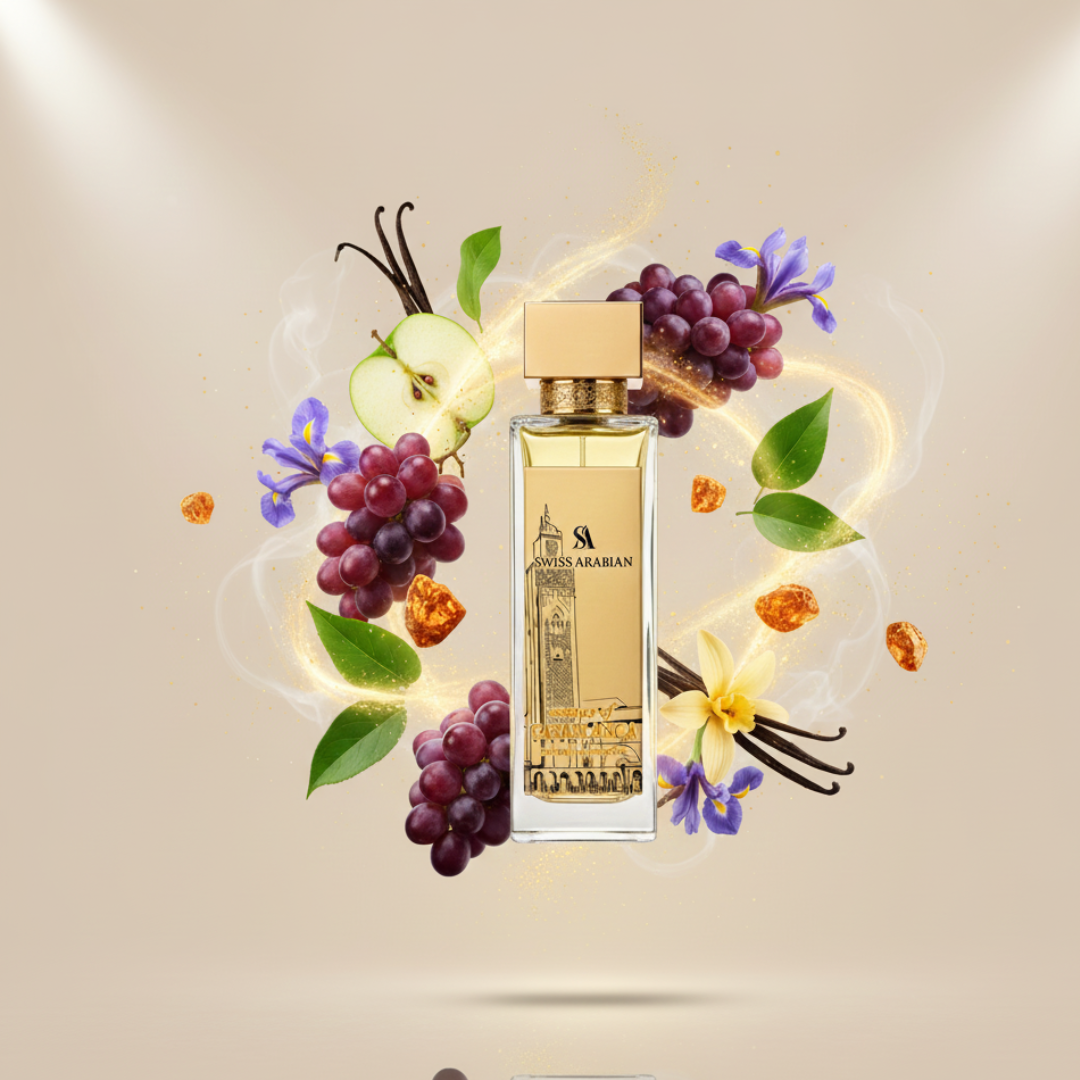The Essence Of Casablanca 100ml EDP by Swiss Arabian is shown gold-capped, surrounded by grapes, apple slices, vanilla beans, amber, green leaves, and purple flowers—evoking its elegant fragrance on a beige background with golden sparkles.
