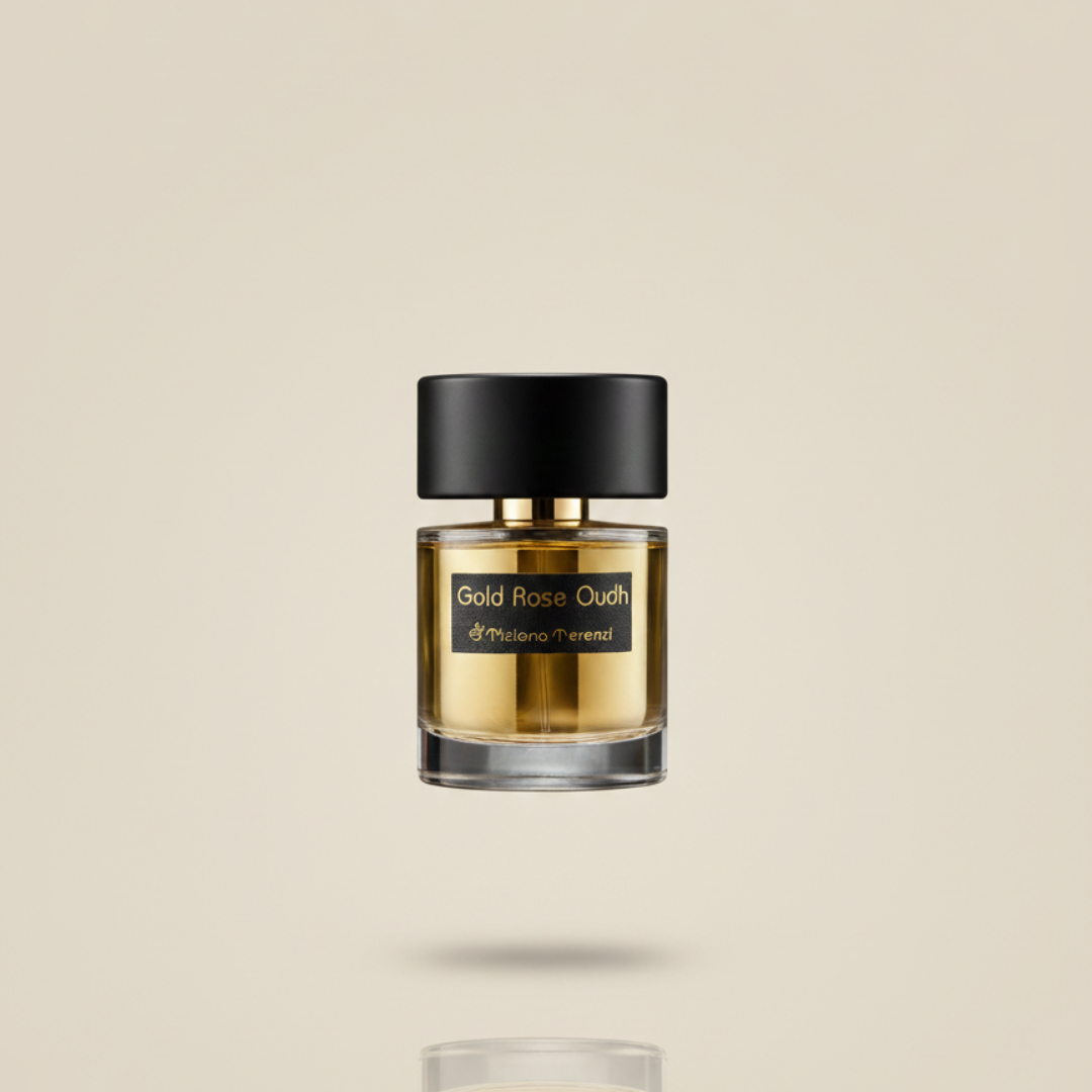 A clear glass bottle of Tiziana Terenzi's Gold Rose Oudh 100ml EDP, a luxurious woody-floral perfume, with a black and gold cap and label, is displayed against a plain beige background.