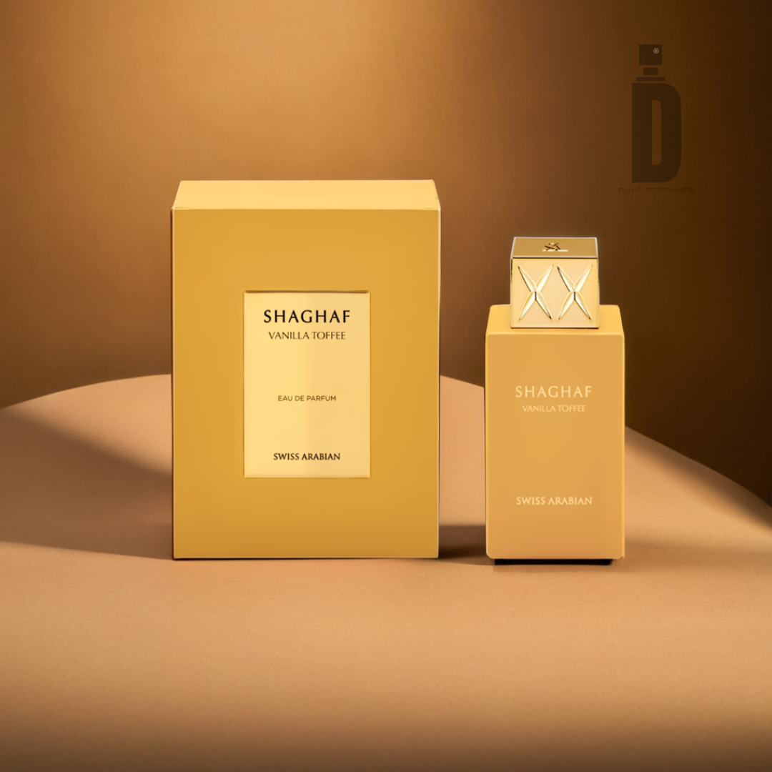 A bottle and box of Shaghaf Vanilla Toffee 75ml EDP by Swiss Arabian are displayed against a brown background. The packaging, with its rich caramel hue, exudes sweet sophistication, featuring elegant typography. This gourmand fragrance presents an indulgent blend that is truly captivating.