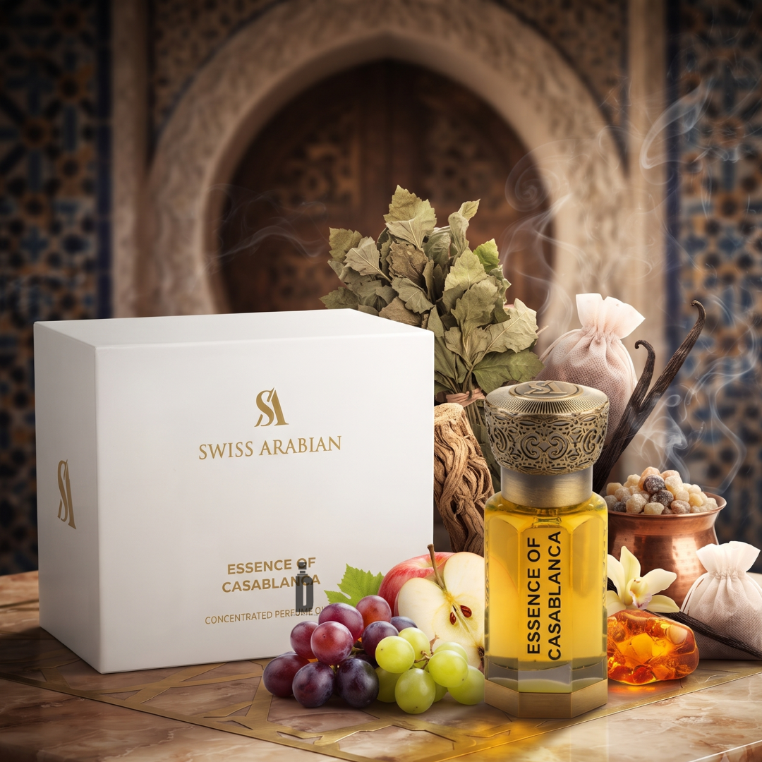 A bottle of Swiss Arabian’s "Essence Of Casablanca 100ml EDP" stands beside its elegant box, encircled by grapes, amber, herbs, and ornamental accents against a backdrop inspired by Moroccan design. This Eau de Parfum embodies refined sophistication and exotic allure, capturing the timeless spirit of Swiss Arabian fragrance craftsmanship.