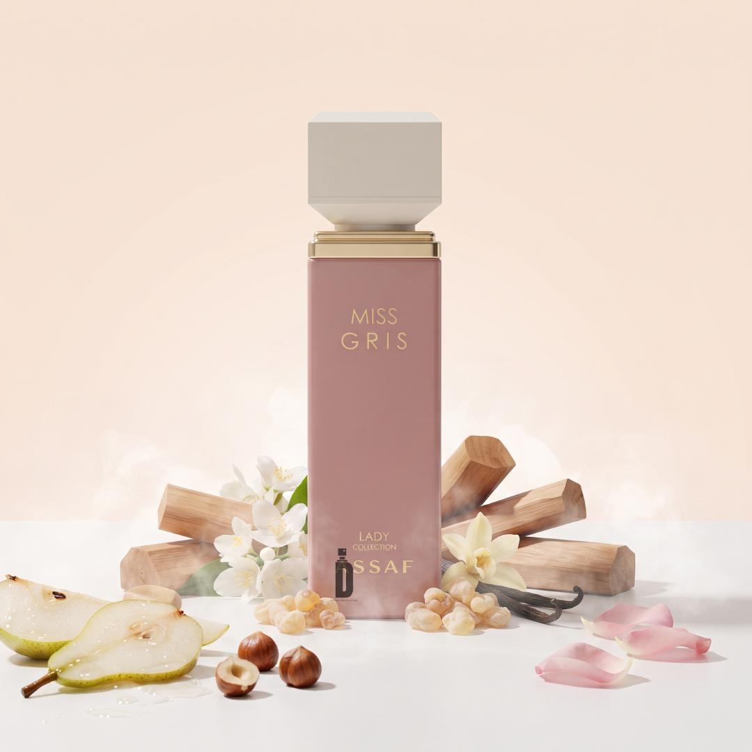 A pink bottle of Miss Gris 100ml EDP by Assaf sits amid pear slices, hazelnuts, vanilla beans, flower petals, and wooden sticks, surrounded by a gentle blush backdrop and delicate mist—an elegant women’s fragrance from Assaf that radiates luxury and sophistication.