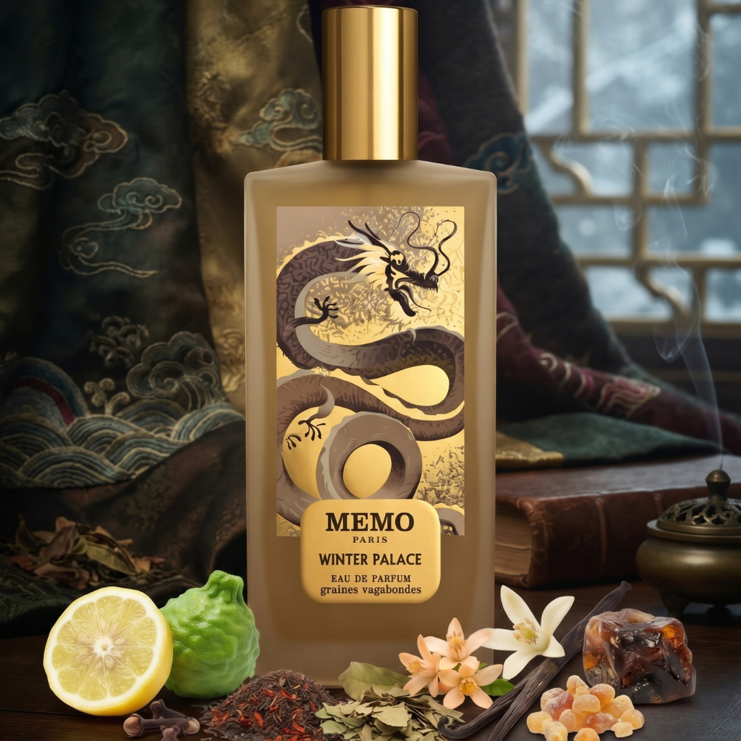 A rectangular Winter Palace 75ml EDP - Memo Paris perfume bottle featuring a gold dragon illustration, surrounded by scattered red tea leaves, citrus fruit, vanilla beans, and flowers.