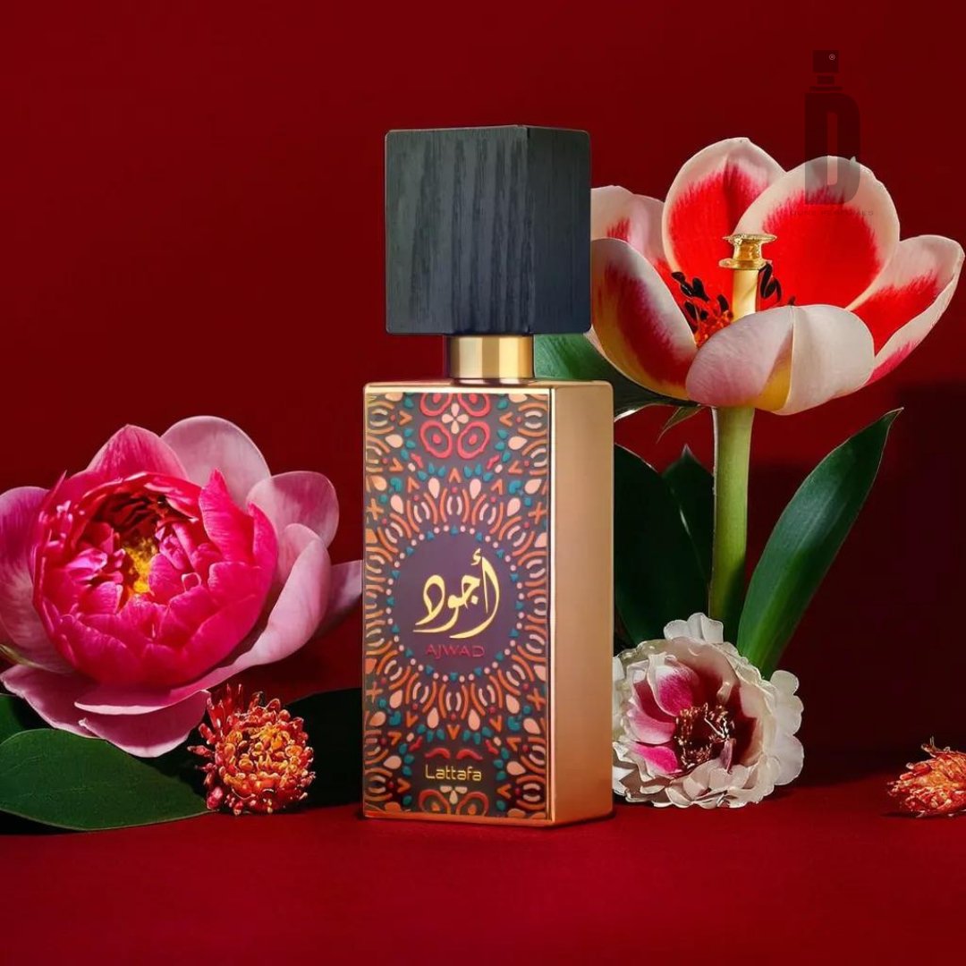 A perfume bottle featuring an intricate gold and red design, labeled "Ajwad 60ml EDP - Lattafa," is set against a rich red background. Surrounded by vibrant peonies and lilies, this sophisticated perfume from Lattafa has a black, square cap. Indulge in the luxurious scent of Ajwad fragrance.