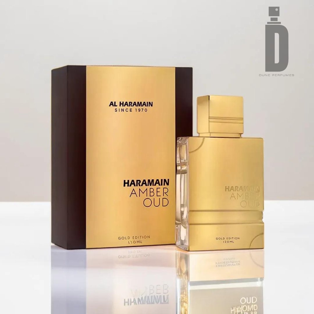 A bottle of Al Haramain Amber Oud Gold Edition 120ml EDP stands next to its elegant packaging. The box is black with a gold front panel, and the bottle is gold with the perfume name inscribed on it. The set, showcasing this luxurious fragrance, is placed on a reflective surface.
