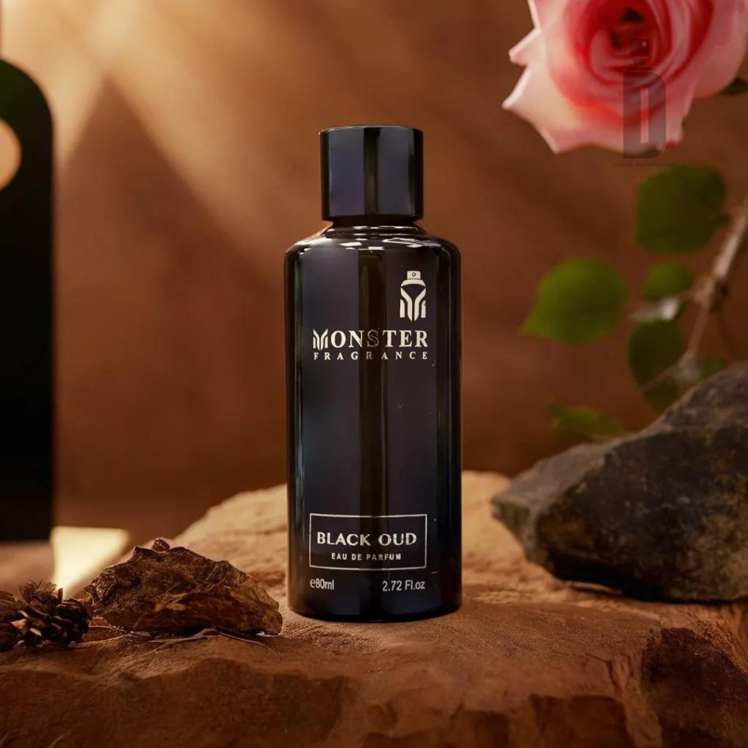 A sleek black bottle of Paris Corner's Black Oud 80ml EDP is displayed on a rock surface. The background features a faintly lit rose and greenery, adding an elegant touch to the scene while hinting at the exotic richness of deep agarwood (oud).