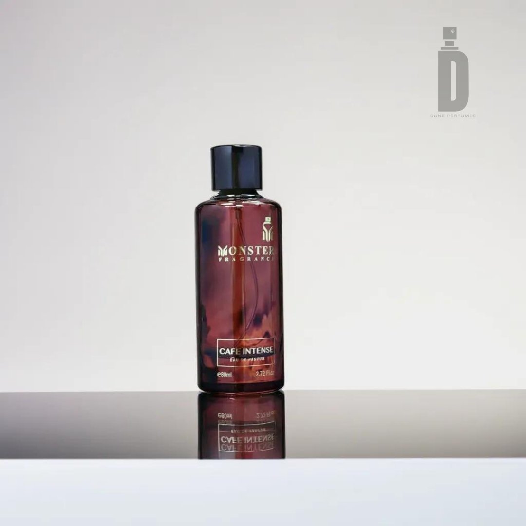 A dark brown bottle labeled "Cafe Intense 80ml EDP - Paris Corner" is known for its subtle floral notes. The bottle, featuring a sleek black cap, sits on a reflective surface against a plain backdrop, with the logo and text elegantly positioned in the upper right corner.